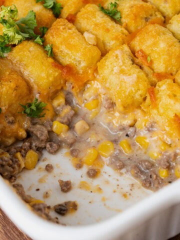 Creamy tater tot casserole in a white baking dish ready to serve.