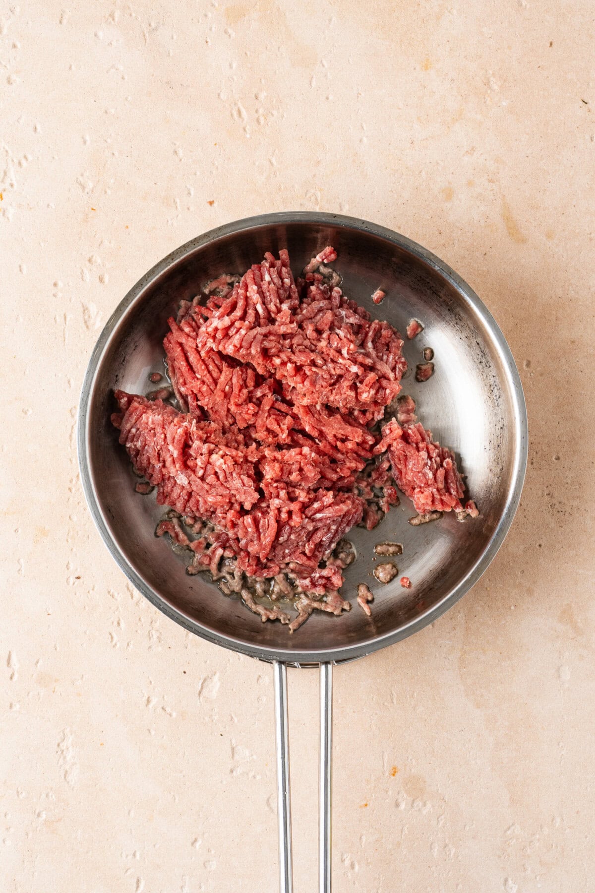 Ground beef cooking until no longer pink in a skillet.
