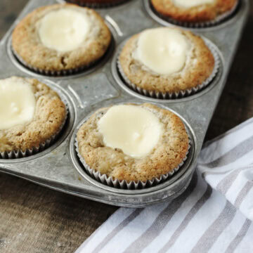 Baked banana cream cheese muffins in a muffin pan.