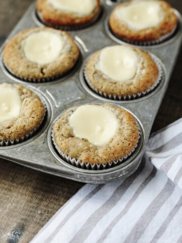 Baked banana cream cheese muffins in a muffin pan.