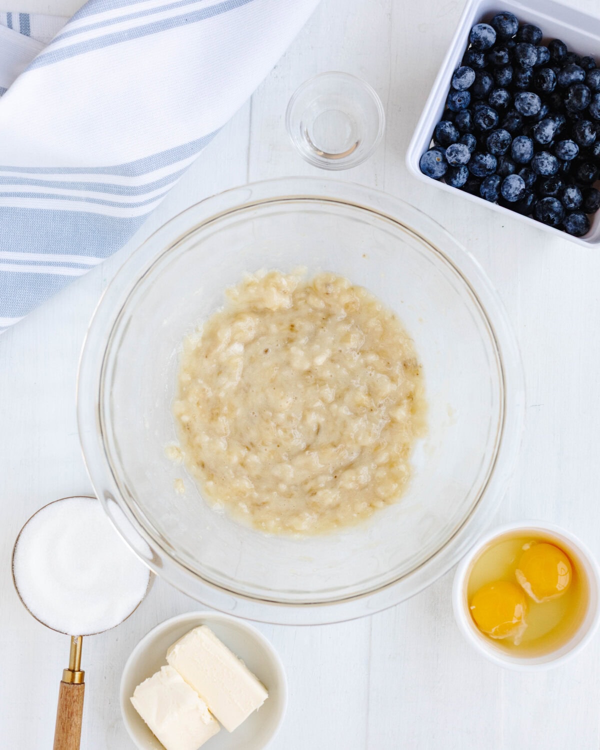 Mashed bananas in a glass mixing bowl.