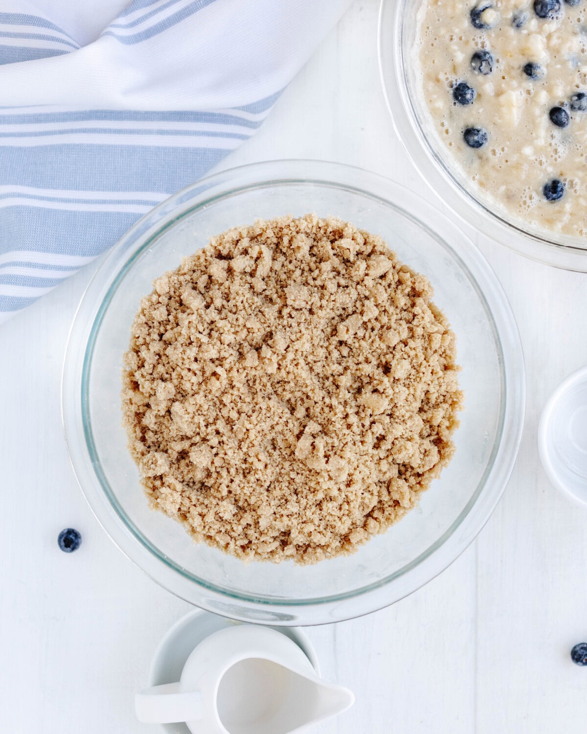 Butter, brown sugar, and flour combined using a pastry blender in a small glass bowl.