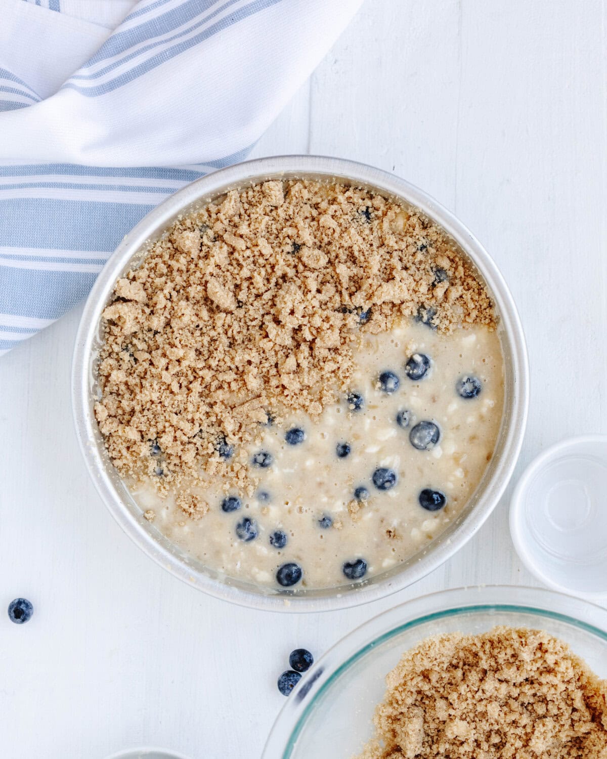 Cake batter topped with a cinnamon streusel topping in a circle baking pan.
