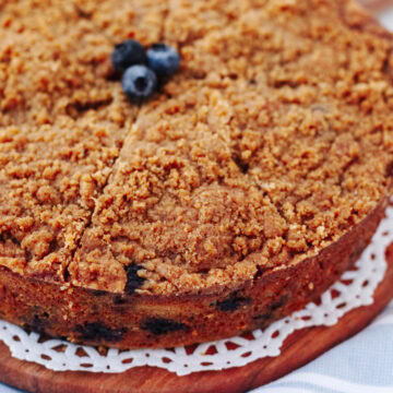 An up close look at blueberry banana crumb cake on a wood serving board.