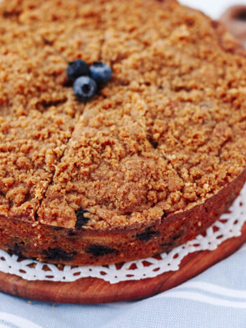 An up close look at blueberry banana crumb cake on a wood serving board.
