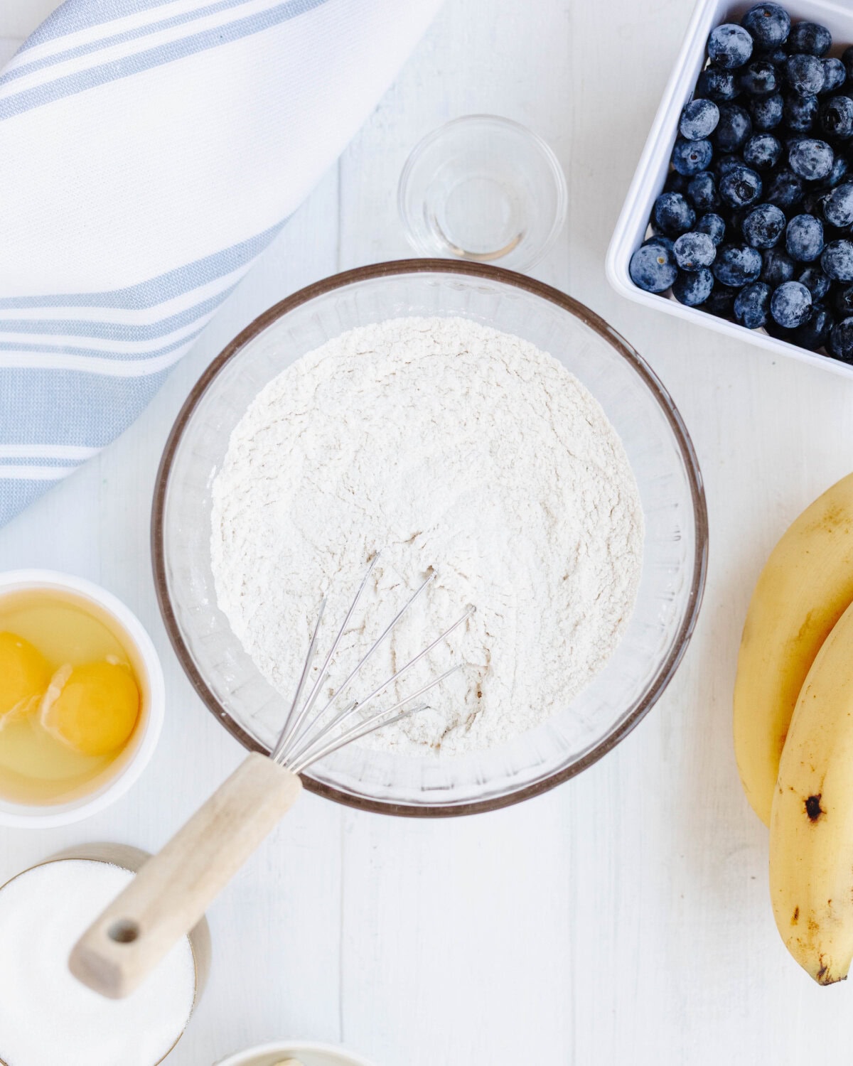 Flour, baking powder, and salt combined in a glass bowl.