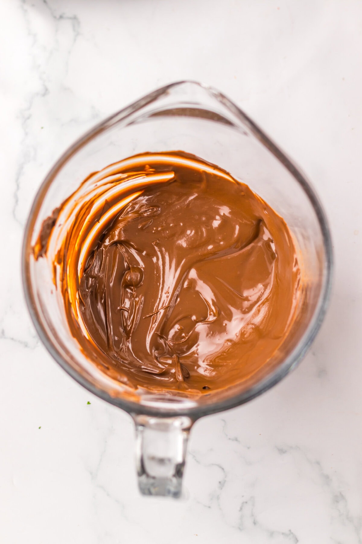 Chocolate almond bark melted in a glass mixing bowl.