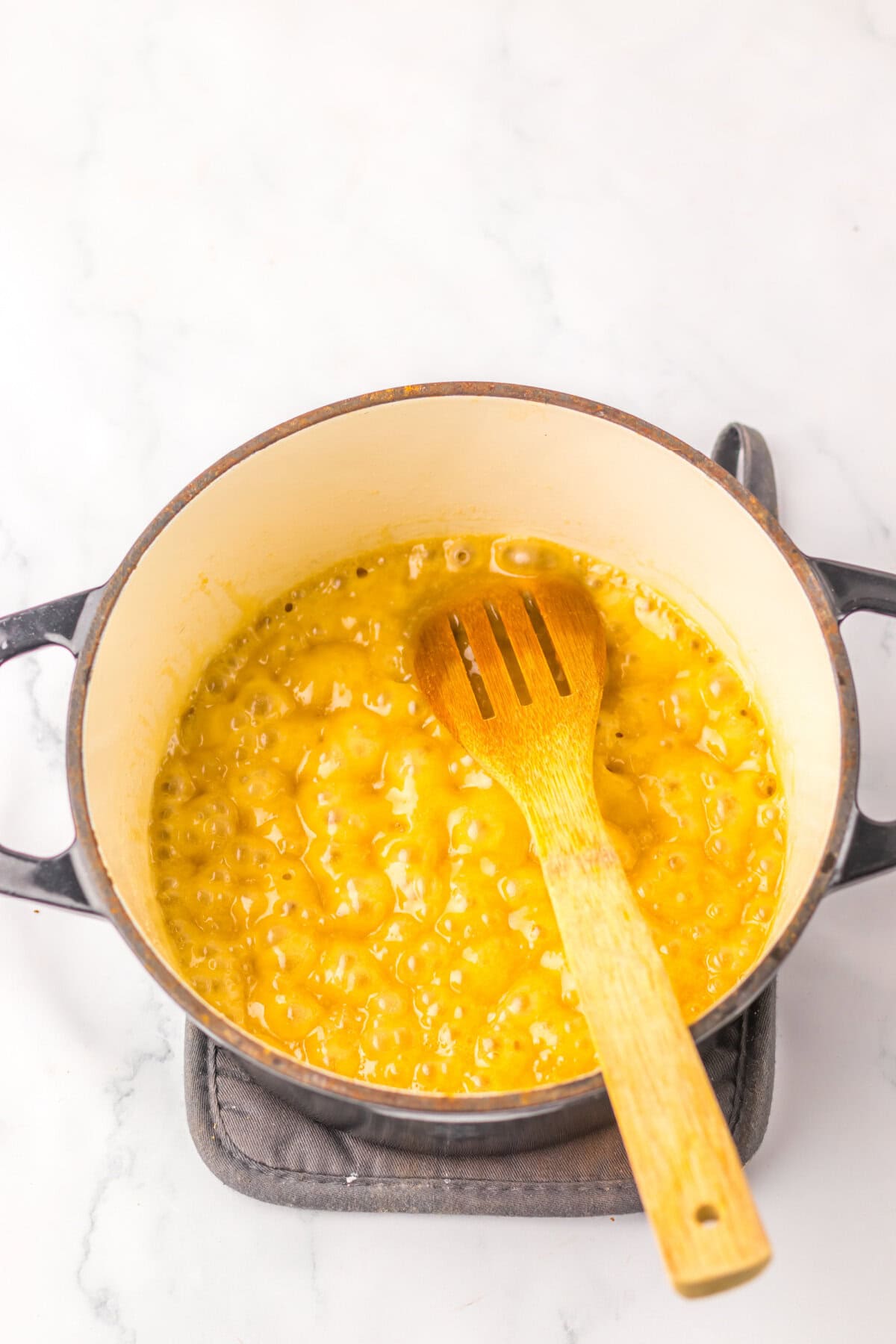 Butter and brown sugar simmering in a large Dutch oven.
