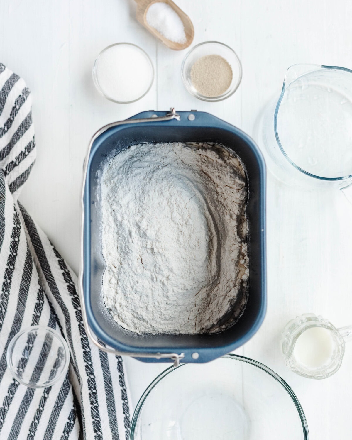 Flour, milk, sugar, and salt added to a bread machine pan.