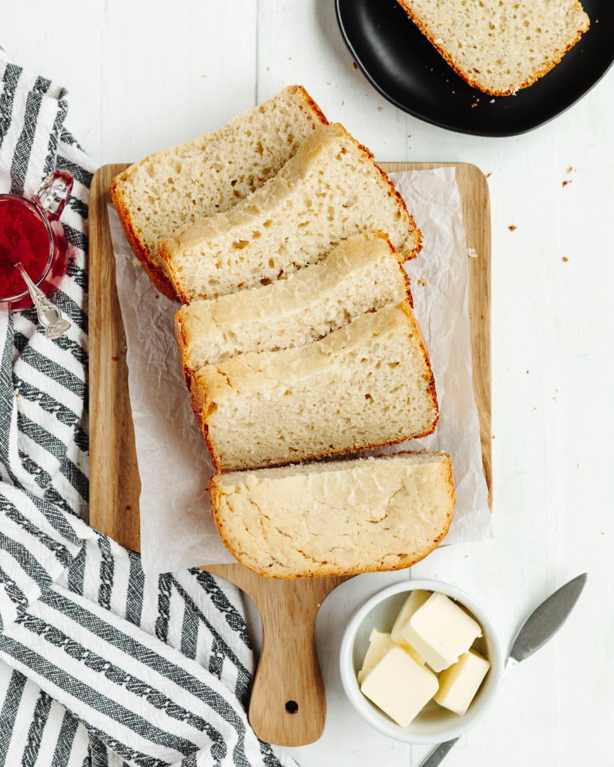 A top view of country white bread sliced on a wood cutting board.