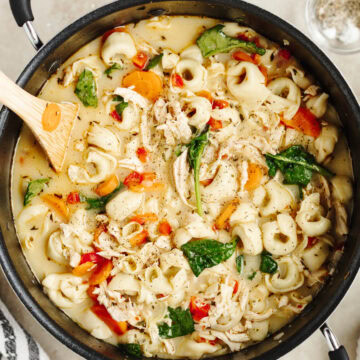 Creamy chicken tortellini soup ready to serve from a soup pot.