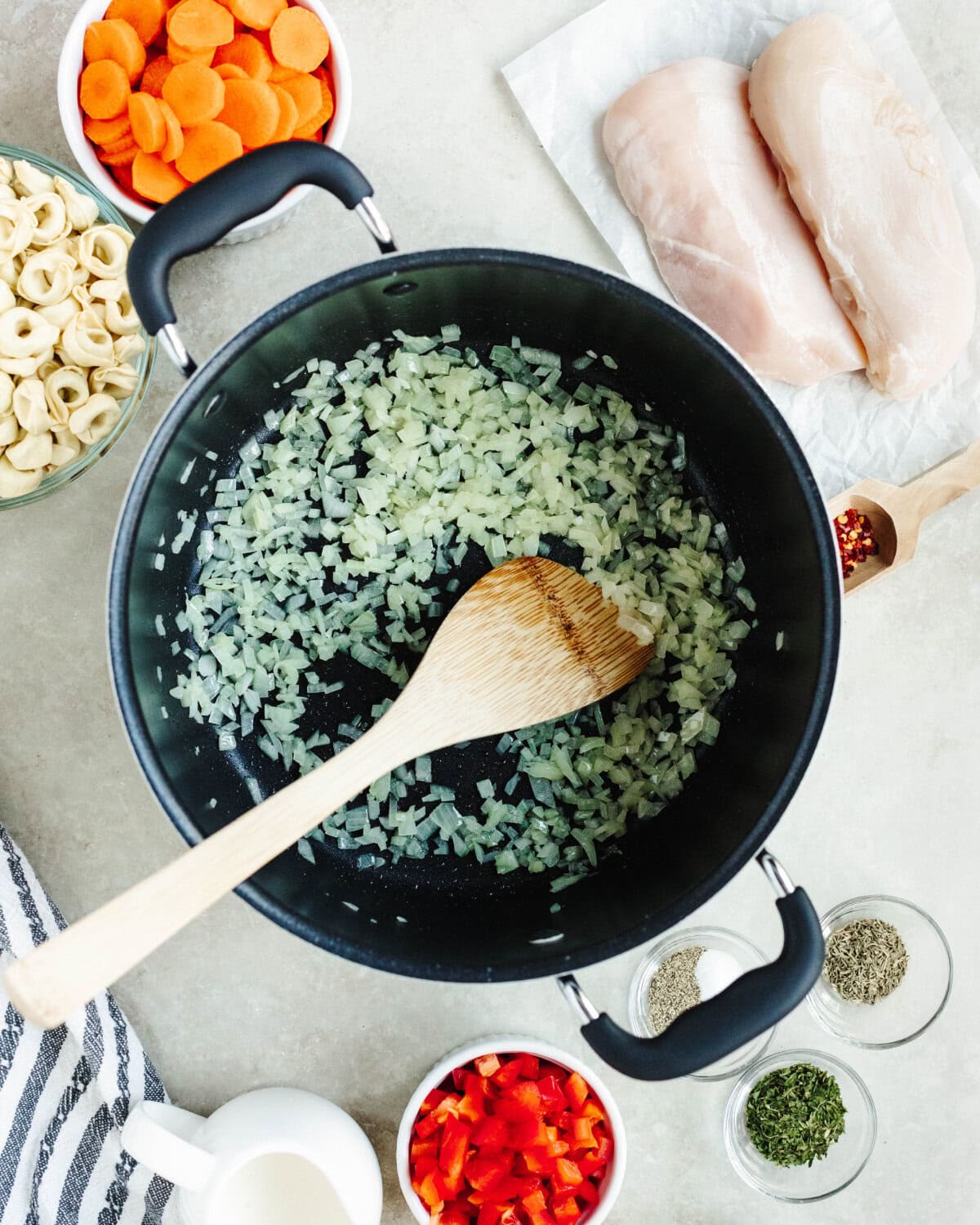 Diced onions cooking in oil until tender in a soup pot.