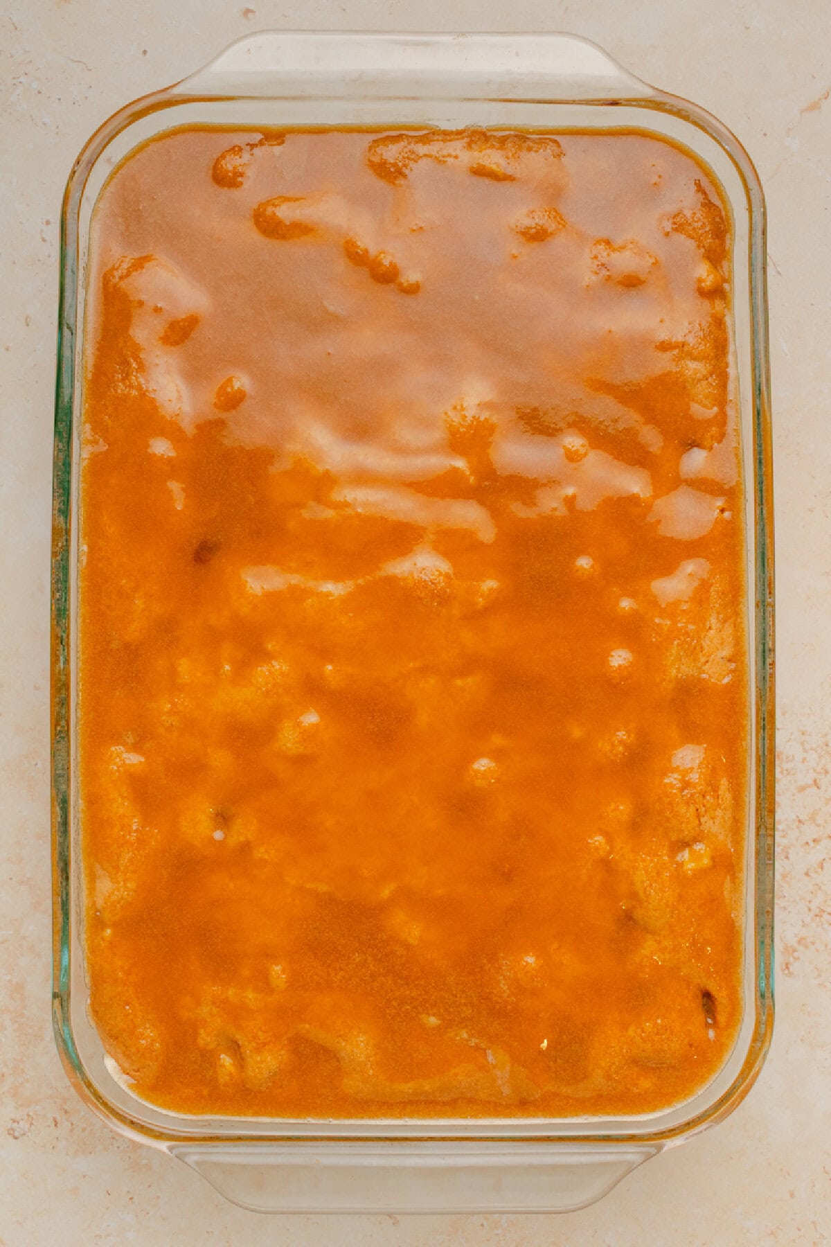 Brown sugar topping poured evenly on top of a baked cake.
