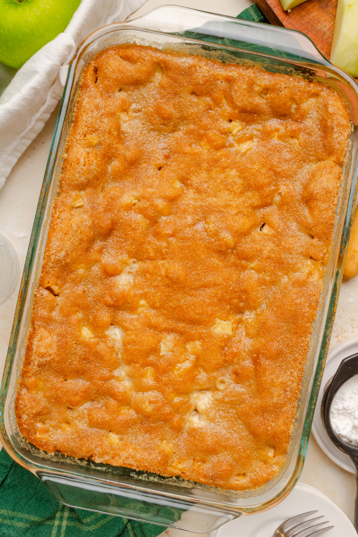 A baked fresh apple cake ready to serve from a glass 9x13 baking pan.