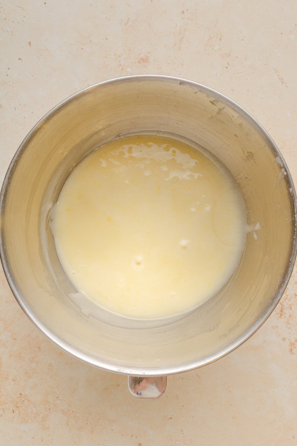 Oil and eggs combined in a mixing bowl.