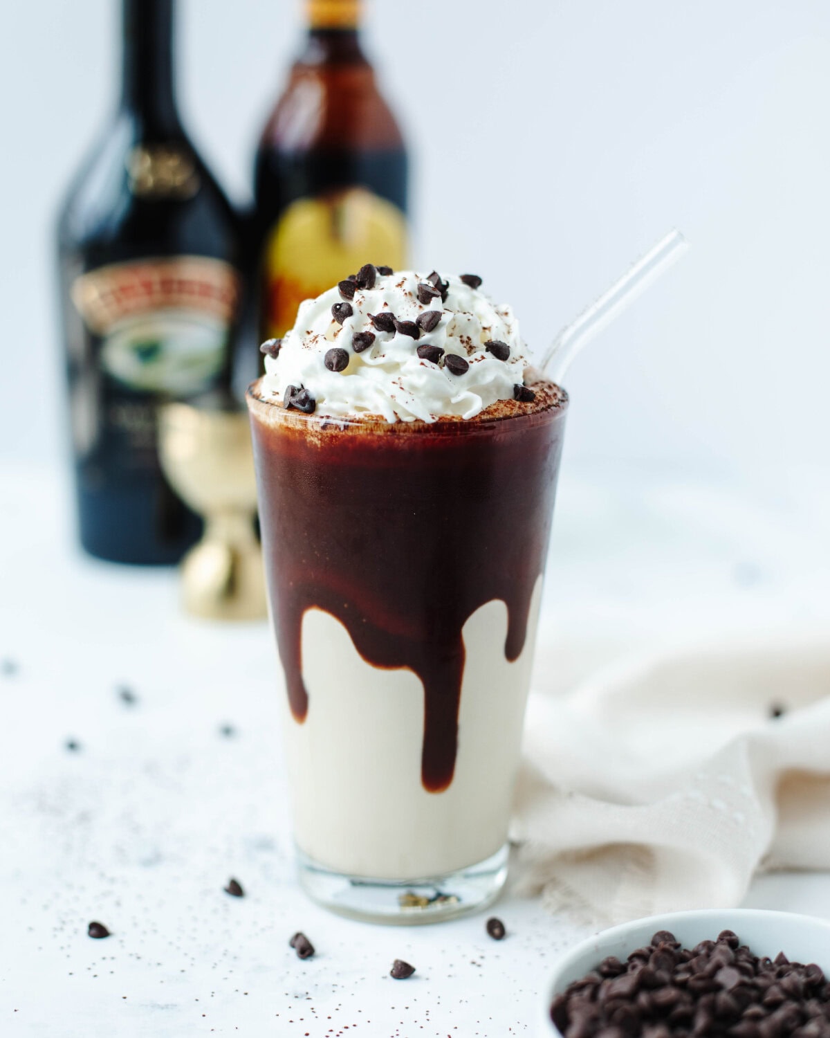 A frozen mudslide in a glass garnished with whipped cream and chocolate syrup.