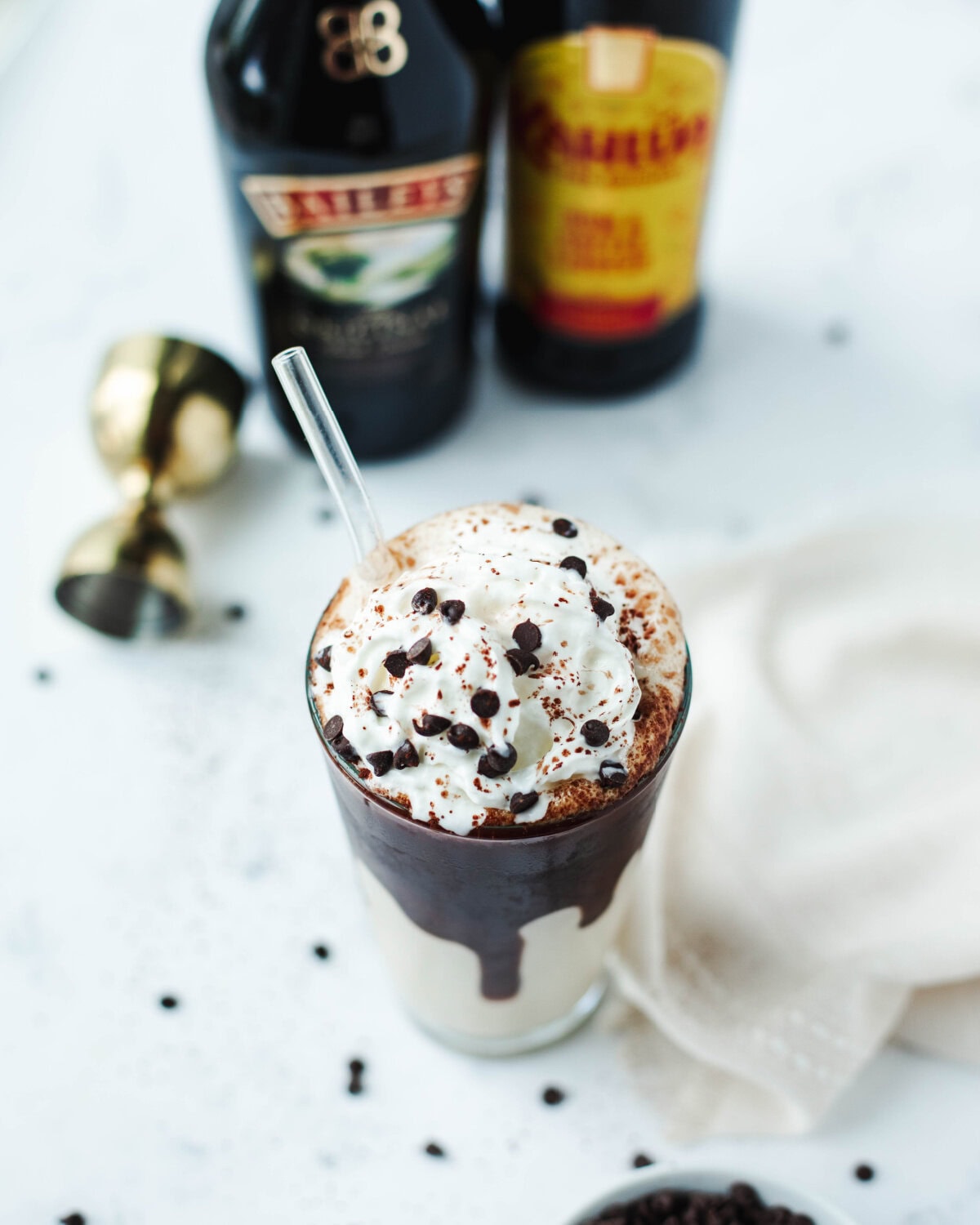 A top view of a frozen mudslide cocktail garnished with whipped cream, chocolate syrup, and sprinkles.