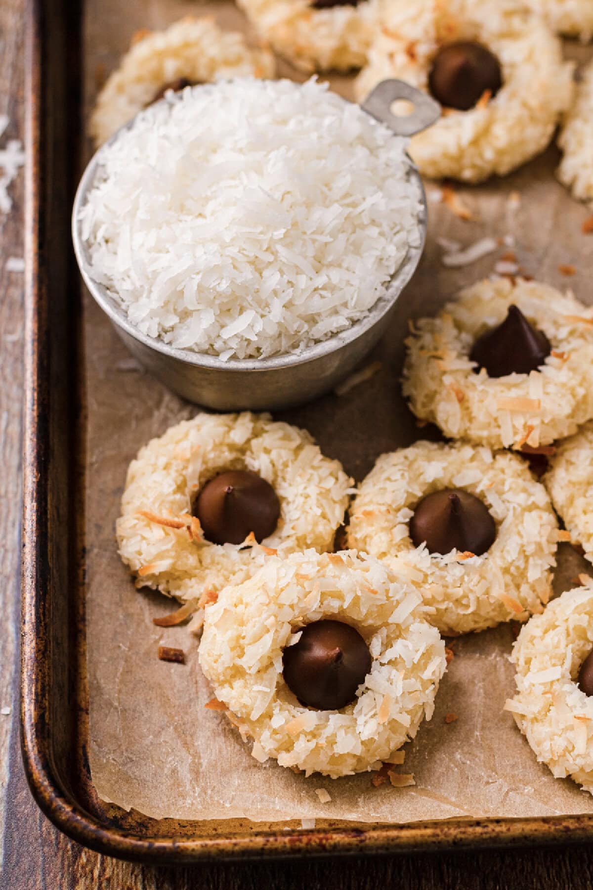 Baked macaroon kiss cookies on a parchment lined cookie sheet.