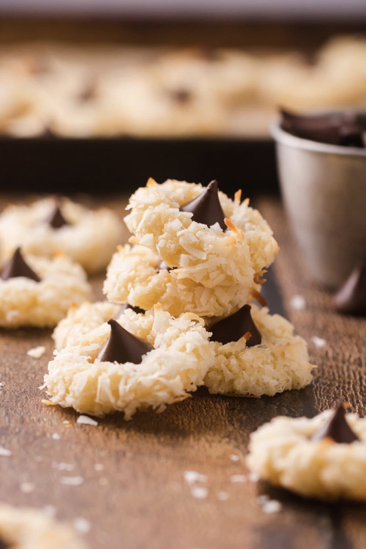 A stack of macaroon kiss cookies on a wood board ready to serve.