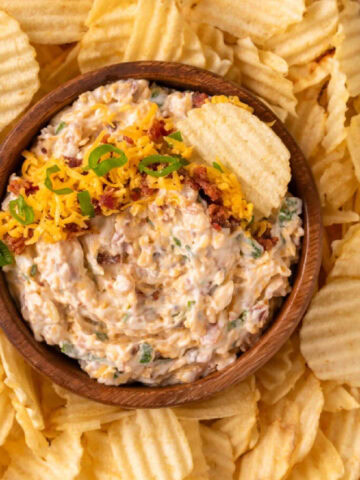 A brown bowl with million dollar dip served with chips.