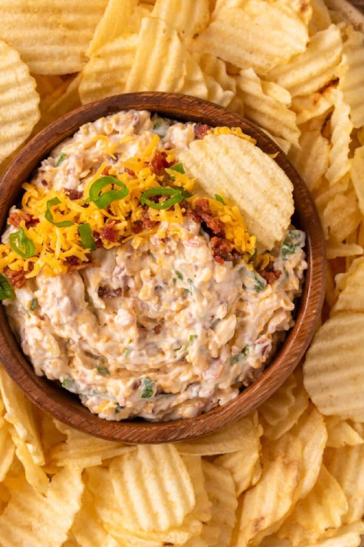 A brown bowl with million dollar dip served with chips.