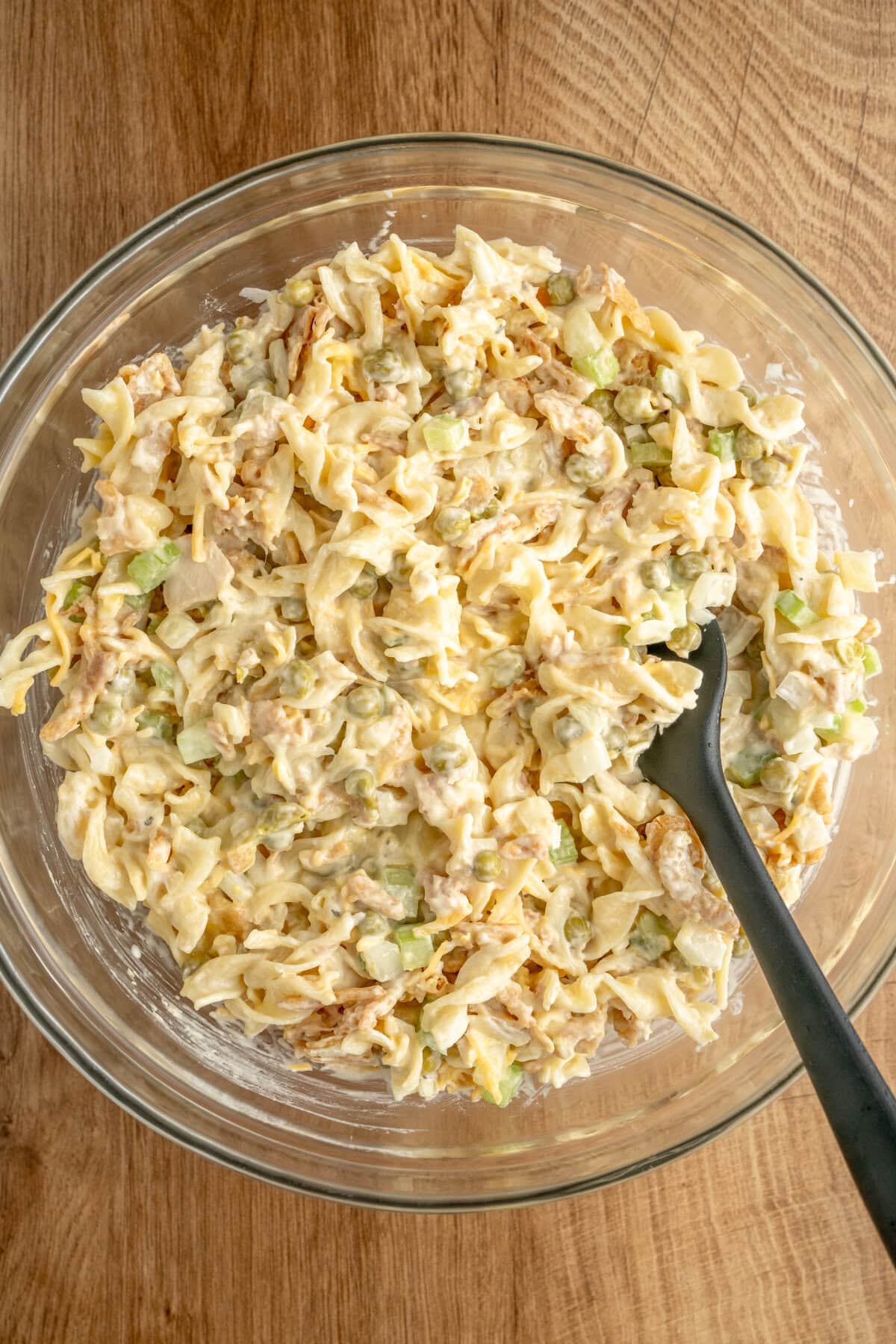 A creamy pasta mixture in a glass mixing bowl.