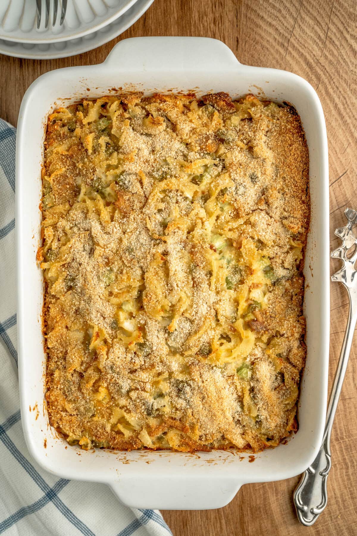 A baked tuna noodle casserole ready to serve from a white baking pan.