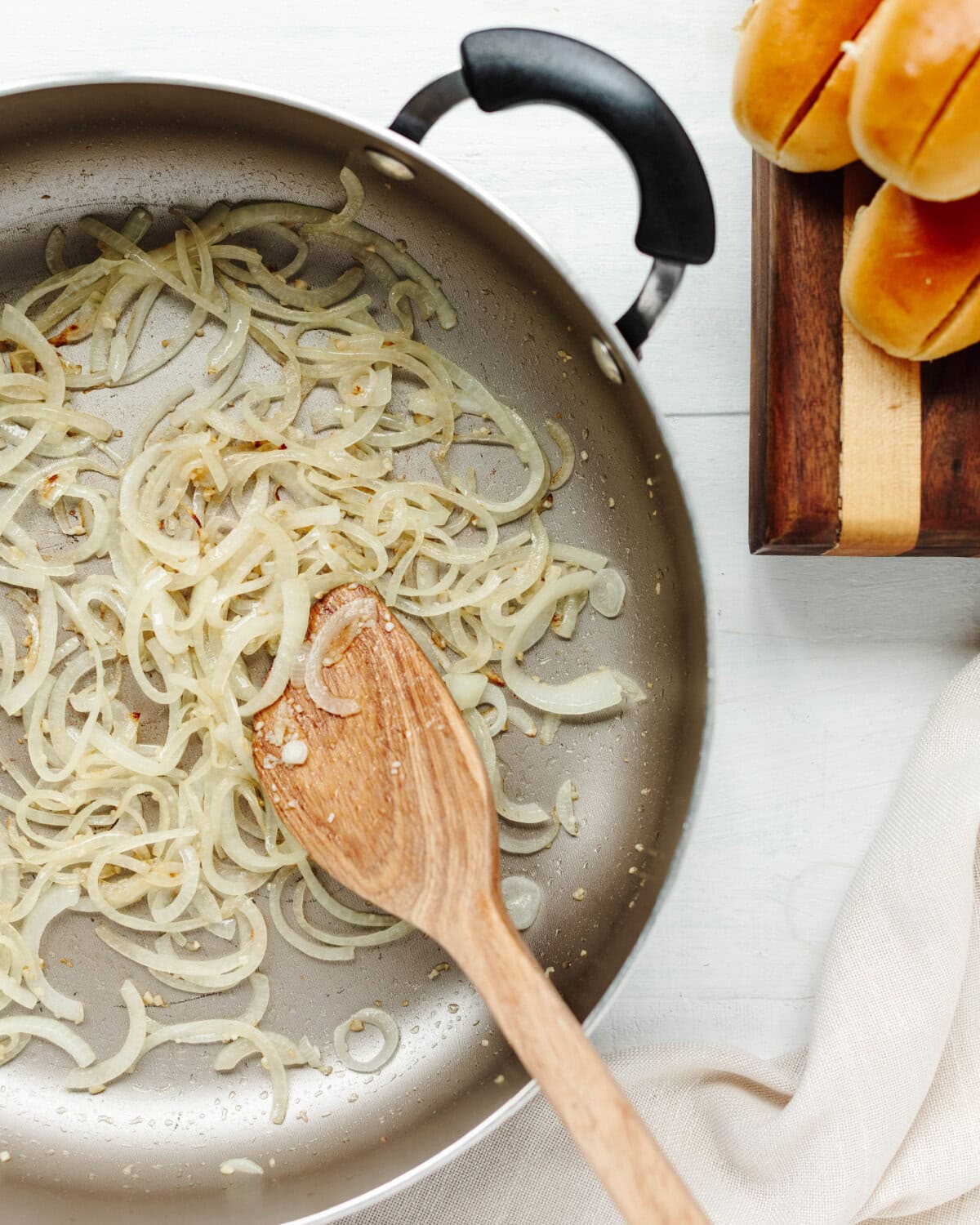Sliced onion and minced garlic cooking in a skillet.