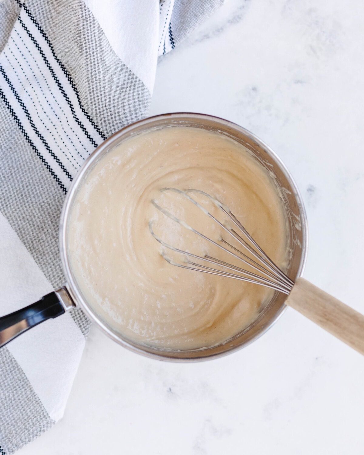 Flour whisked into heated bacon grease with evaporated milk folded in.