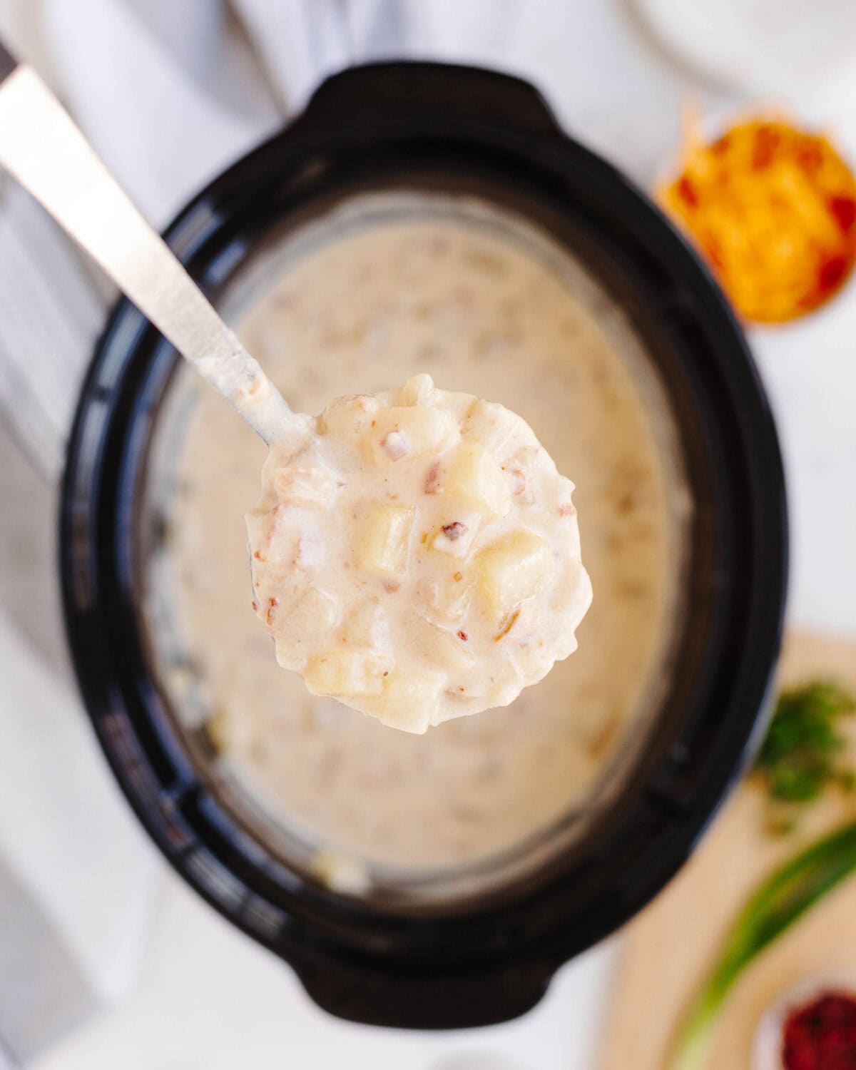 A spoon scooping potato soup to show the chunky texture.